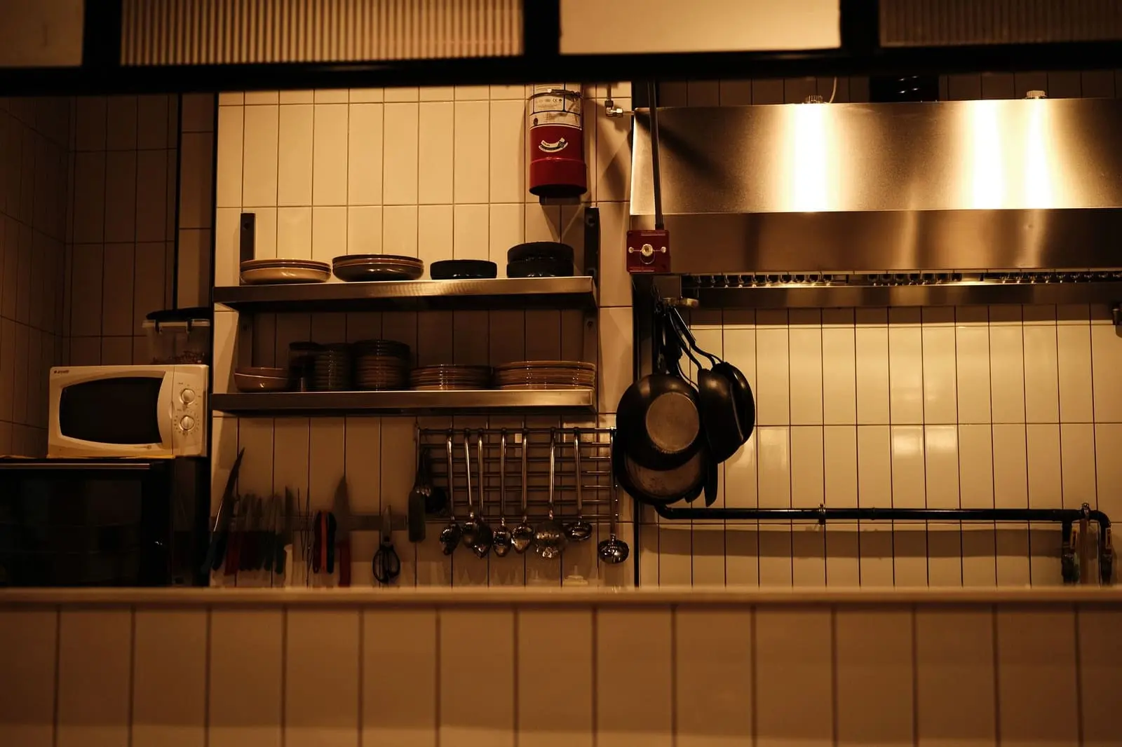 Hotte d'extraction inox et étagères d'une cuisine de restaurant carrelée, illustration Biohotte Nuisibles, Nanterre